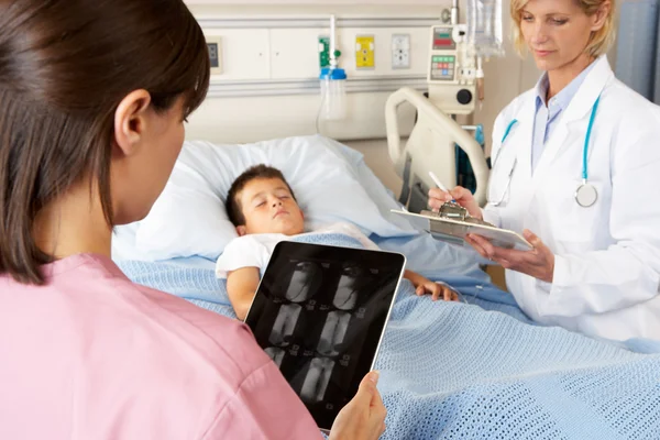 Médico usando bloc de notas digital mientras visita al paciente infantil — Foto de Stock