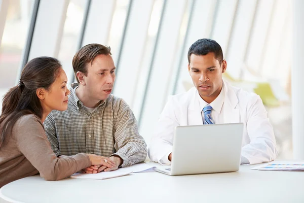 Médico usando laptop discutindo o tratamento com pacientes — Fotografia de Stock