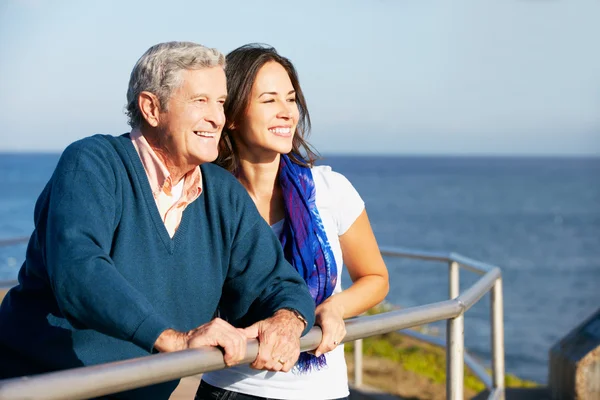 Senior man met volwassen dochter kijkt uit over de reling op zee — Stockfoto