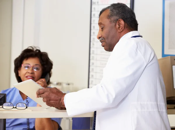 Médico en discusión con enfermera en el puesto de enfermeras — Foto de Stock