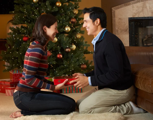 Paar openen presenteert voor de kerstboom — Stockfoto