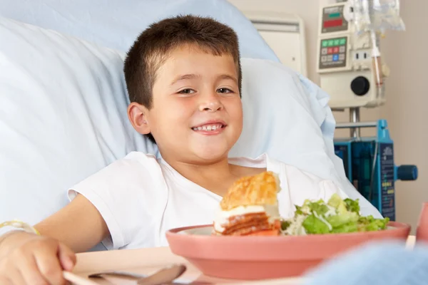 Jongen het eten van maaltijd in ziekenhuisbed — Stockfoto