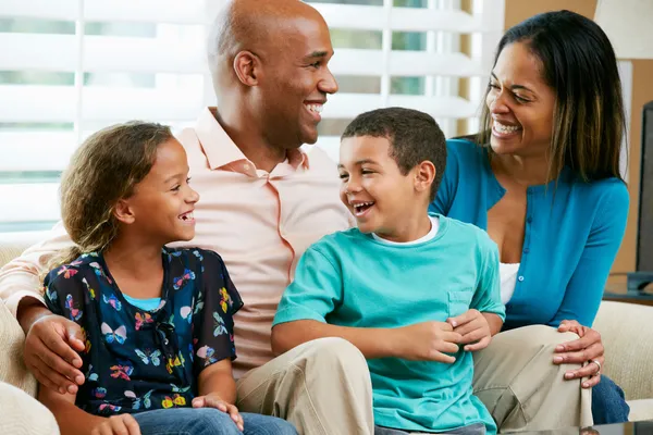 Familia sentada en un sofá juntos — Foto de Stock