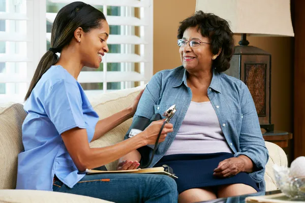 Krankenschwester besucht Seniorin zu Hause — Stockfoto