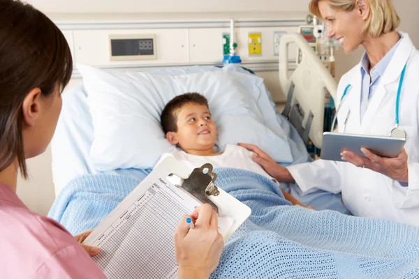 Médico usando bloco de notas digital enquanto visita paciente infantil — Fotografia de Stock