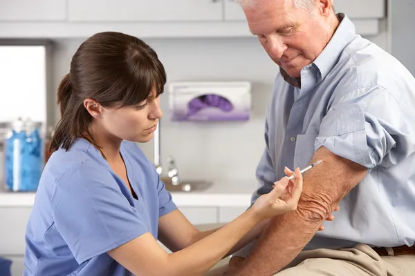 Médico que da la inyección masculina del paciente — Foto de Stock