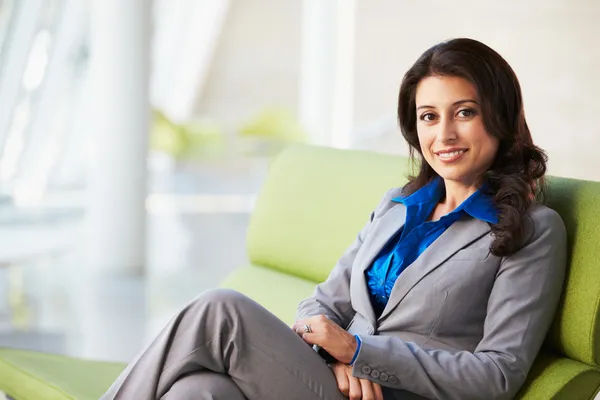 Ritratto di donna d'affari seduta sul divano in ufficio moderno — Foto Stock