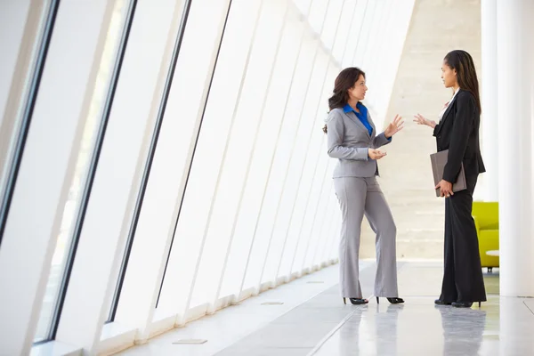 Two Businesswomen Having Informal Meeting In Modern Office Stock Picture
