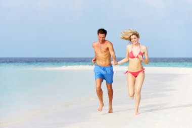 Romantic Couple Running On Beautiful Tropical Beach clipart