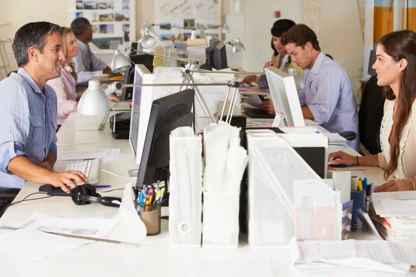 Trabajo en equipo en escritorios en oficinas ocupadas — Foto de Stock