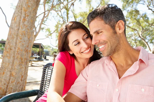 Romantiska par sitter på parkbänk tillsammans — Stockfoto