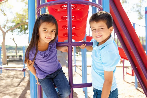 Menino e menina no quadro de escalada no parque — Fotografia de Stock