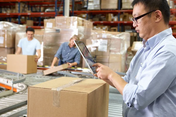 Trabalhador usando o computador Tablet no armazém de distribuição — Fotografia de Stock