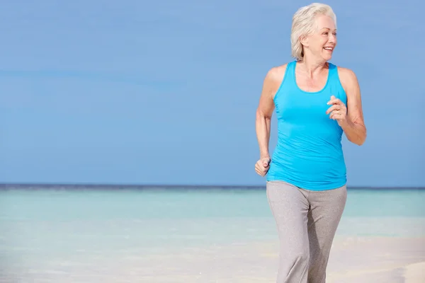 Senior mulher correndo em bela praia — Fotografia de Stock