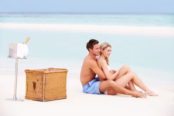 Pareja en la playa con un picnic de lujo con champán —  Fotos de Stock