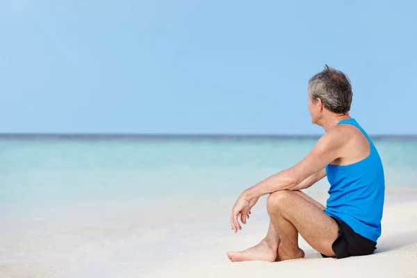 Uomo anziano in abbigliamento sportivo Relax sulla bella spiaggia — Foto Stock