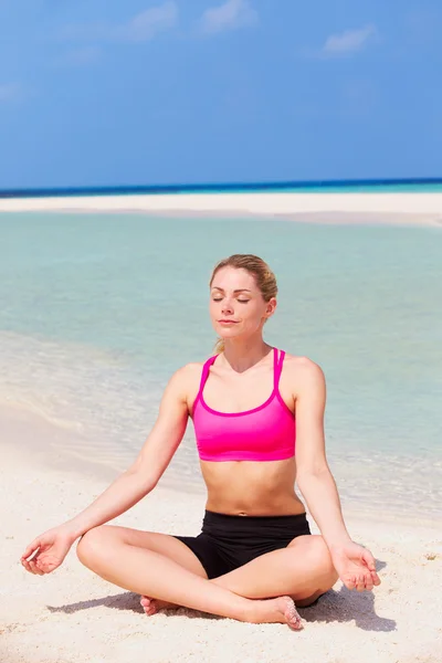 Женщина медитирует на прекрасном пляже — стоковое фото