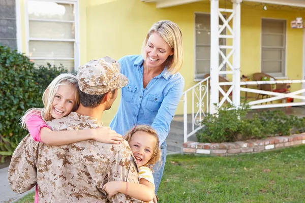 Familia bienvenida marido en casa en licencia del ejército — Foto de Stock