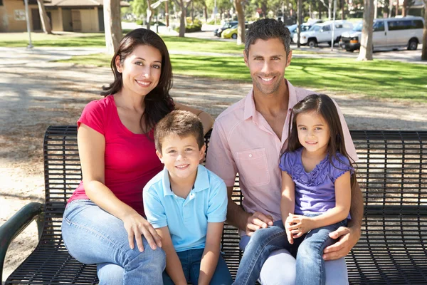 Une famille assise sur le banc du parc ensemble — Photo