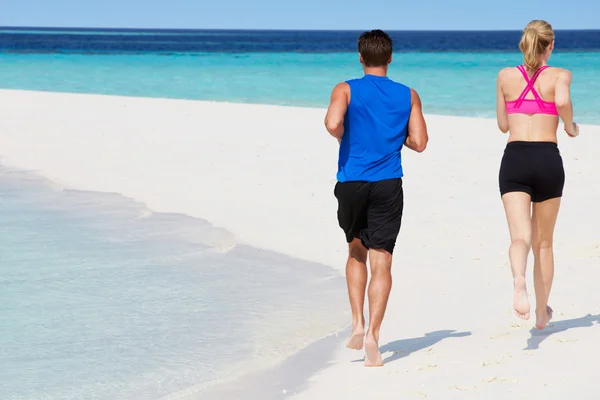 Visão traseira do casal correndo na bela praia — Fotografia de Stock