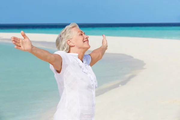 Donna anziana con le braccia distese su bella spiaggia — Foto Stock