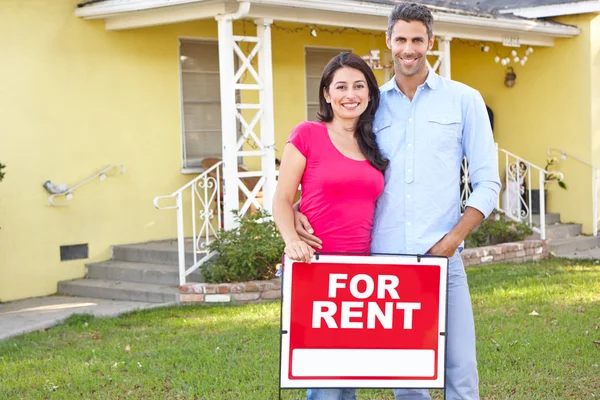 Paar staande door voor huur teken buiten huis — Stockfoto