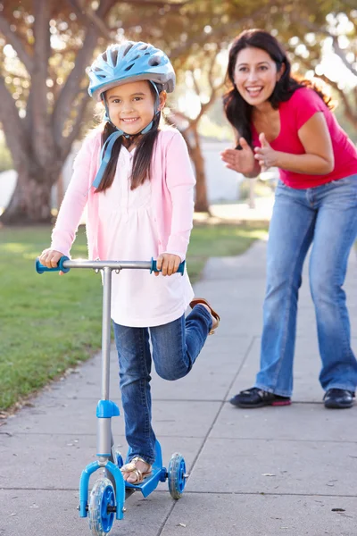 Madre enseñando hija a montar scooter —  Fotos de Stock