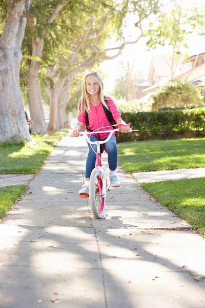 Flickan bär ryggsäck cykling till skolan — Stockfoto