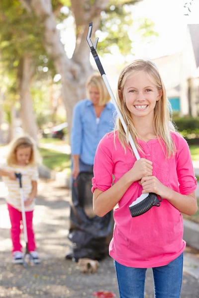 Madre e figlie raccogliendo litter in Suburban Street — Foto Stock