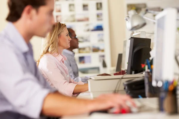 Werknemers bij bureaus in drukke creatieve kantoor — Stockfoto