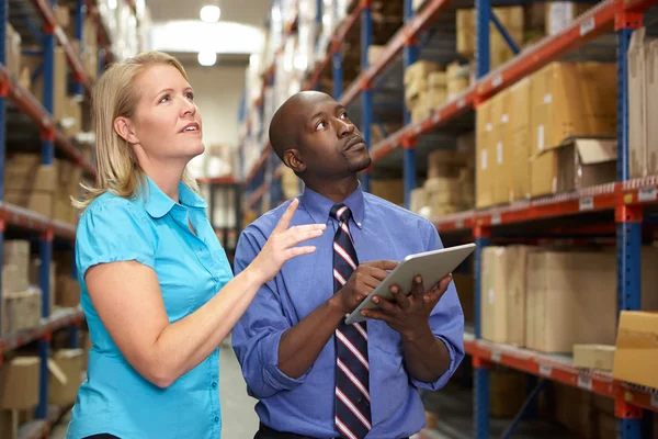 Empresarios con tableta digital en almacén — Foto de Stock