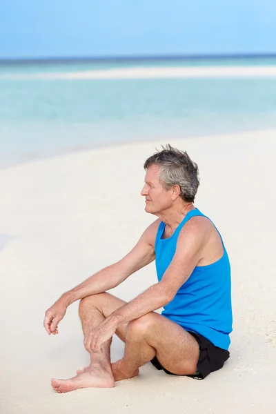 Homme âgé en vêtements de sport se détendre sur la belle plage — Photo