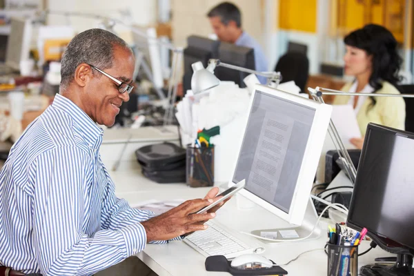 Hombre usando tableta digital en oficina creativa ocupada — Foto de Stock