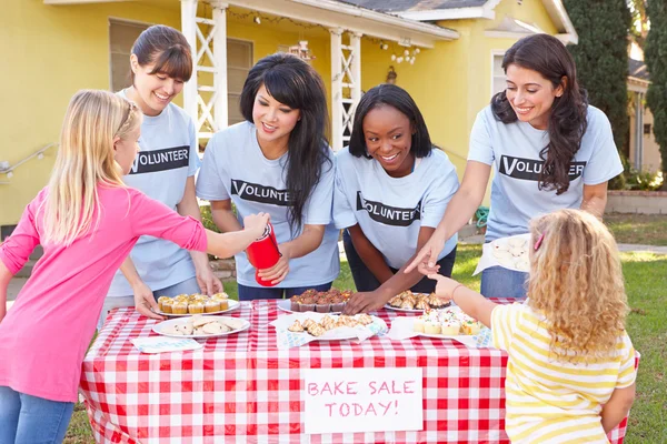 Donne e bambini che gestiscono la vendita di dolci di beneficenza — Foto Stock