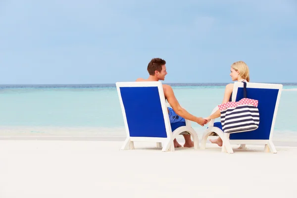 Paar entspannt sich am Strand in Liegestühlen — Stockfoto