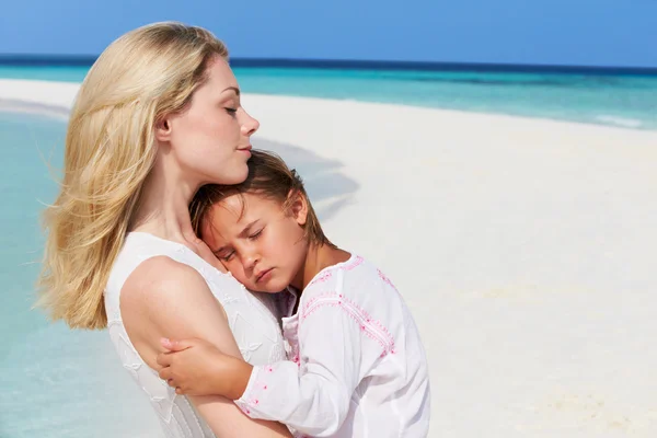 Moeder en dochter knuffelen op strand — Stockfoto