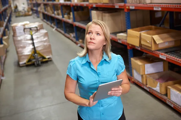 Empresária usando tablet digital no armazém de distribuição — Fotografia de Stock