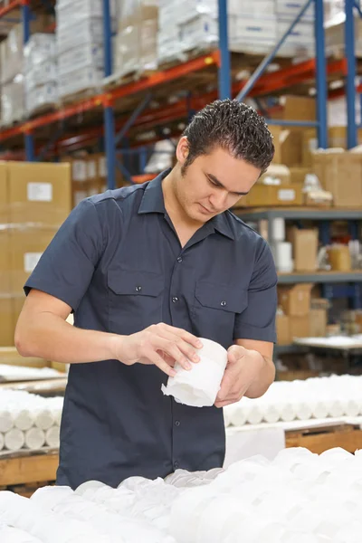 Trabajador de fábrica que comprueba mercancías en línea de producción — Foto de Stock