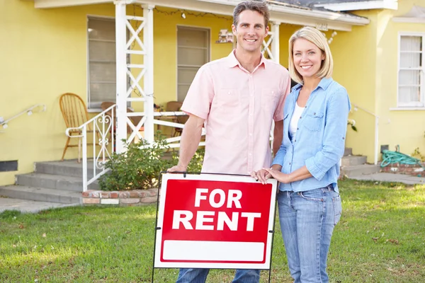 Couple Standing By For Rent Sign Outside Home — Stock Photo, Image