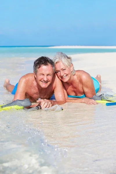 Casal sênior com snorkels desfrutando de férias na praia — Fotografia de Stock