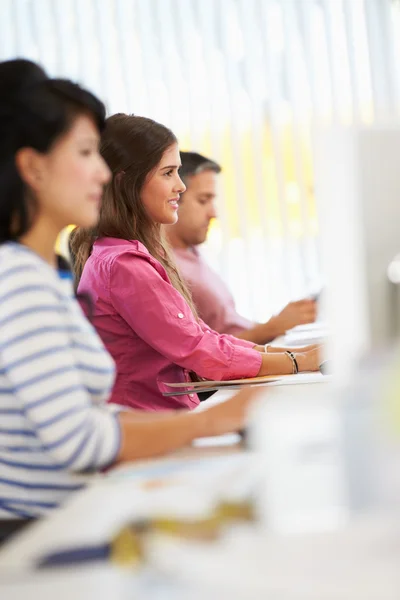 Mujer trabajando en el escritorio en la oficina creativa ocupada — Foto de Stock