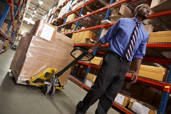 Man trekken pallet in magazijn — Stockfoto