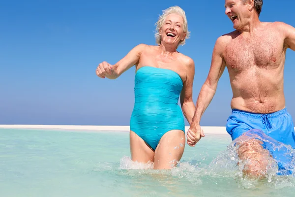 Senior coppia having divertimento in mare su spiaggia vacanza — Foto Stock