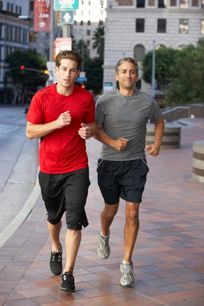 Двое мужчин бегут по городской улице — стоковое фото