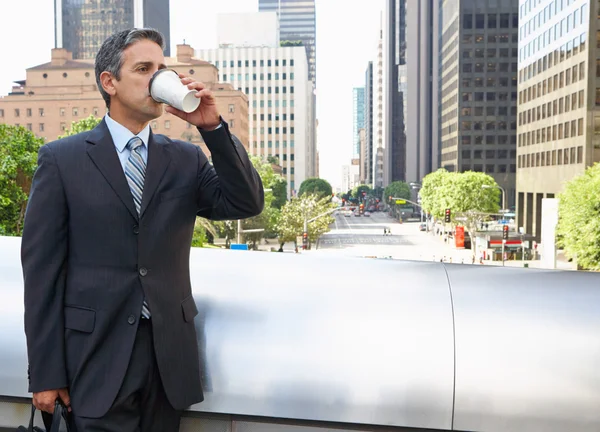 Uomo d'affari bere caffè da asporto fuori ufficio — Foto Stock