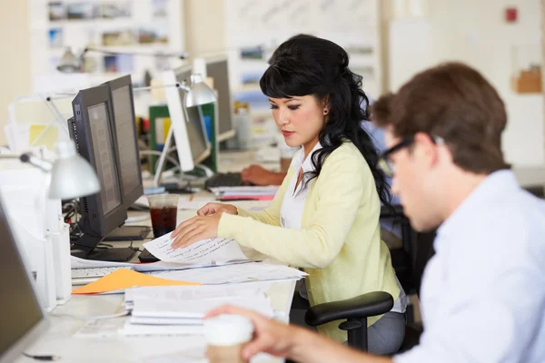 Vrouw werken bij Bureau in drukke creatieve kantoor — Stockfoto