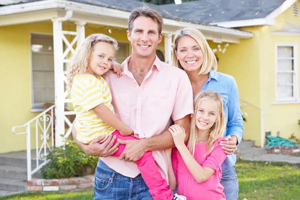 Familie staande buiten suburban huis — Stockfoto