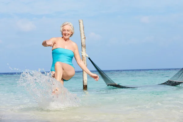 Mujer mayor salpicando en hermoso mar tropical — Foto de Stock