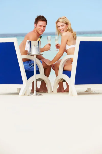 Pareja en la playa relajarse en sillas y beber champán —  Fotos de Stock