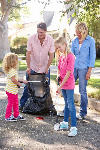 Семья собирает мусор на пригородной улице — стоковое фото